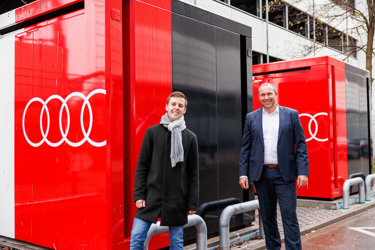 Alexander Jakob (r.), Leiter der Werkstrukturplanung Neckarsulm, und Jannik Mastall, Projektverantwortlicher für den Ausbau der Ladeinfrastruktur am Standort vor den neuen Lade-Cubes.